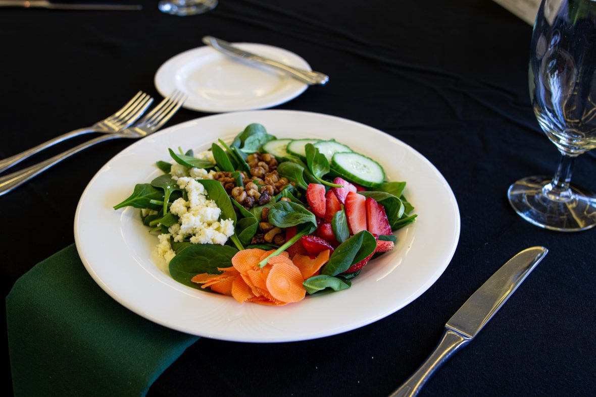 plate of salad on black tablecloth with utensils