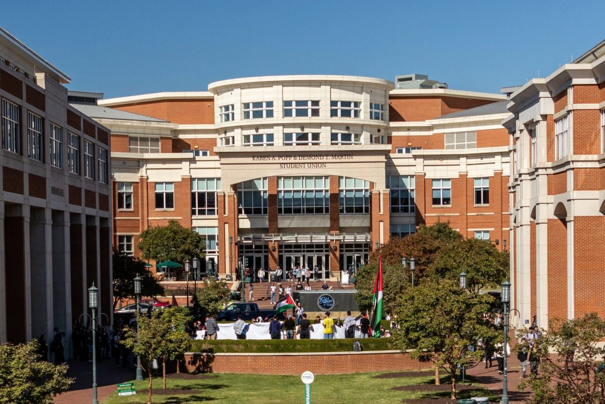 Outside view of Popp Martin Student union with trees, students, and blue sky
