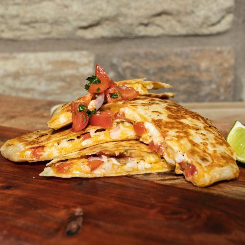 sliced quesadilla on table with a lime