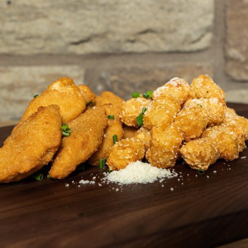 fried appetizer items on wooden board