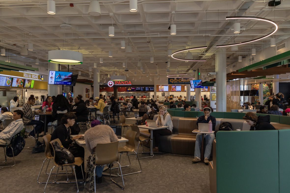 People sitting at tables and walking around a food court